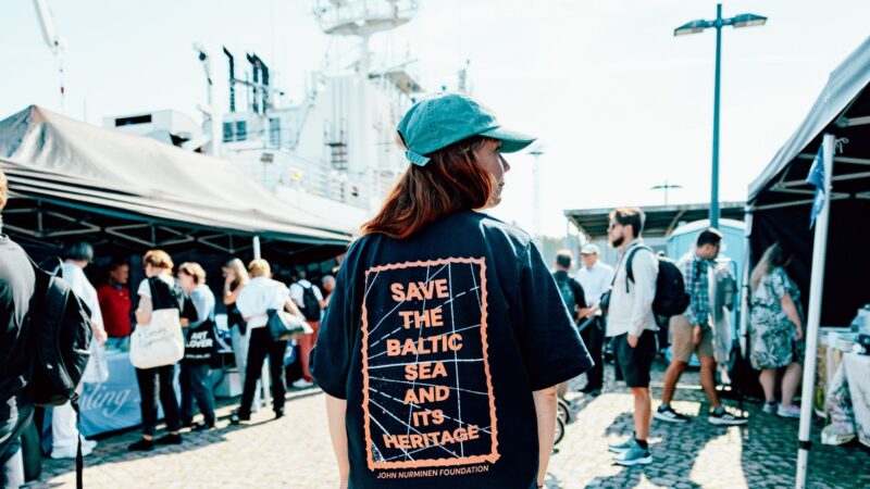 Ihminen selkä edellä kameraan katsomassa festaritelttoja